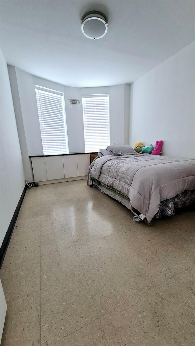 bedroom with baseboards and tile patterned floors