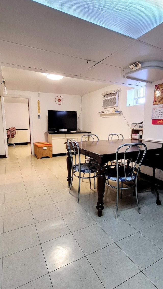 dining area with a wall mounted AC and light tile patterned flooring