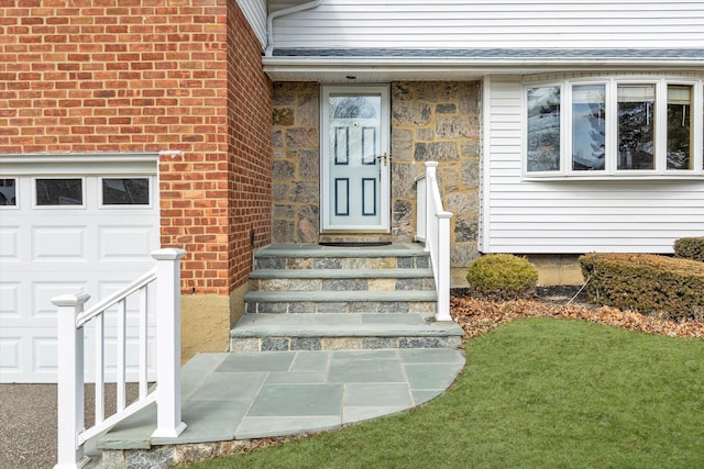 property entrance with a garage and brick siding