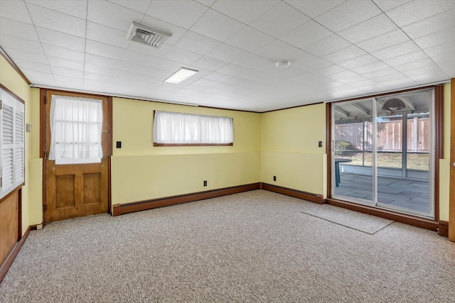 unfurnished room featuring carpet floors, visible vents, and baseboards