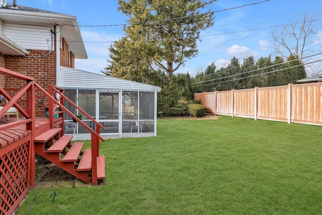 view of yard with a sunroom, fence, and stairway