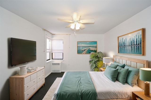 bedroom featuring radiator, baseboards, dark colored carpet, and a ceiling fan