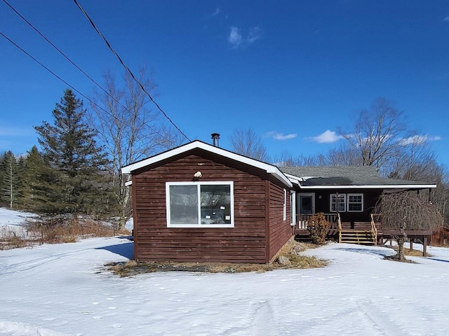 view of snow covered back of property