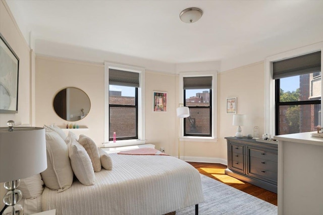 bedroom with baseboards and wood finished floors