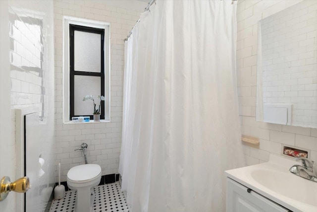 full bath featuring toilet, vanity, tile walls, and tile patterned floors