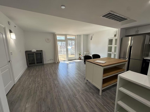 kitchen featuring visible vents, dark wood-style floors, open floor plan, freestanding refrigerator, and open shelves