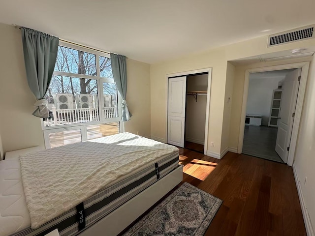 bedroom featuring baseboards, a closet, visible vents, and dark wood-style flooring