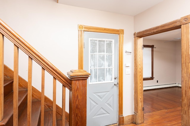 interior space featuring a baseboard heating unit and wood finished floors