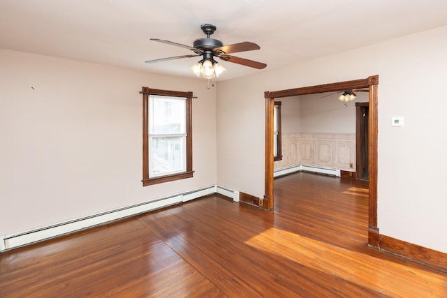 unfurnished room featuring a baseboard radiator, baseboards, and wood finished floors