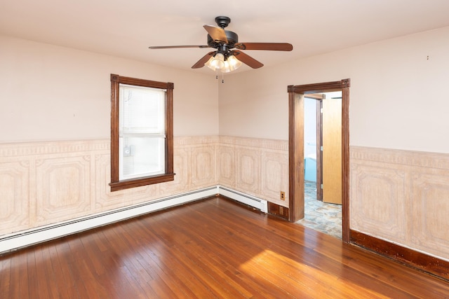 spare room with a baseboard radiator, wood-type flooring, and ceiling fan