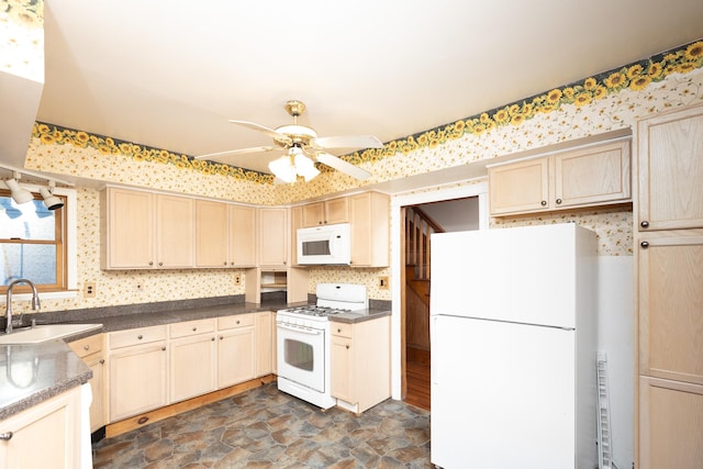 kitchen with white appliances, a sink, a ceiling fan, stone finish flooring, and dark countertops