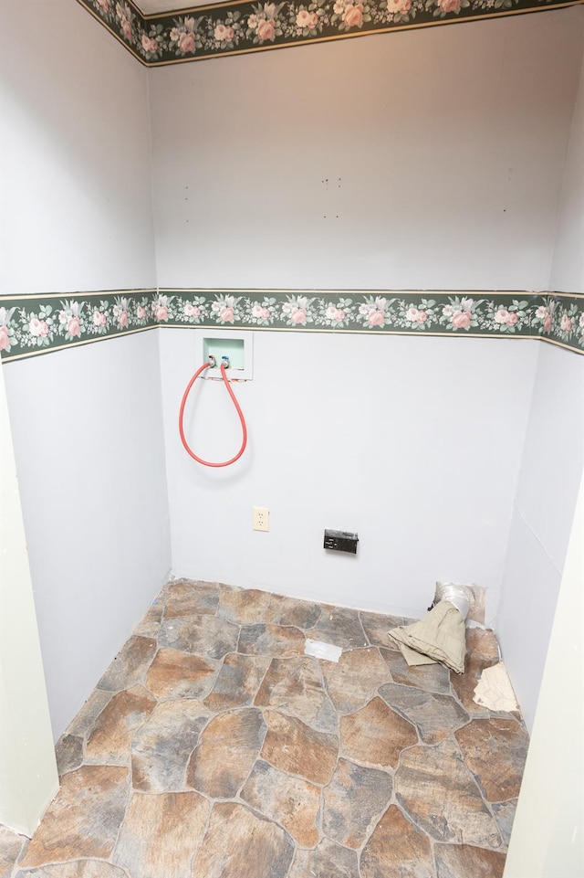 laundry area featuring washer hookup, stone finish floor, and laundry area