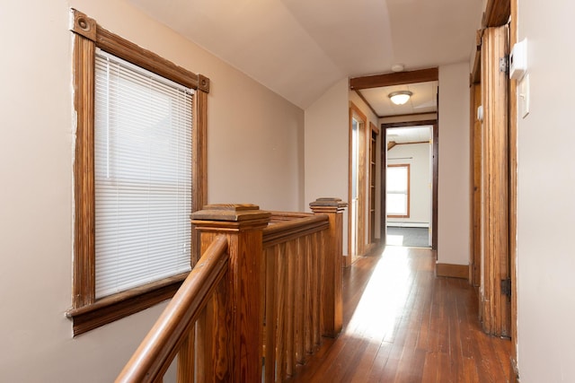 hall featuring a baseboard heating unit, baseboards, an upstairs landing, and hardwood / wood-style flooring