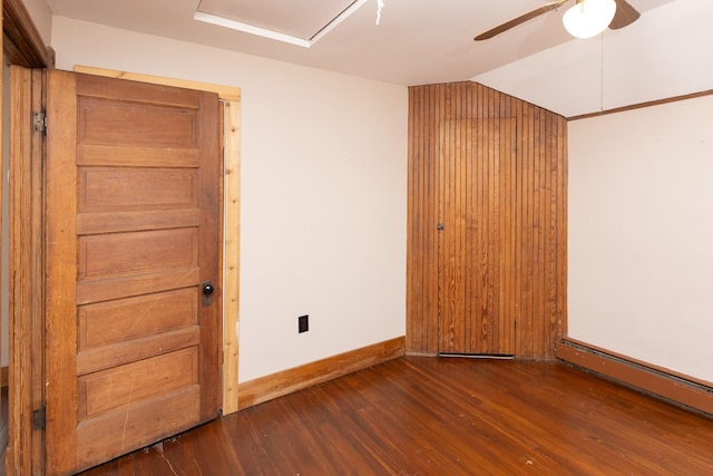 empty room featuring baseboards, a ceiling fan, vaulted ceiling, and wood finished floors