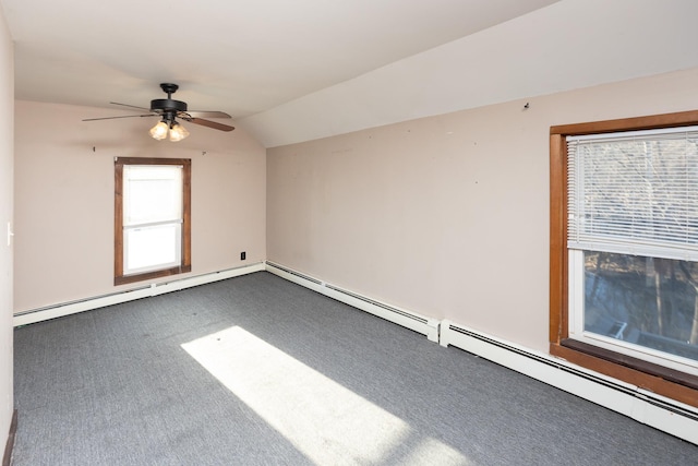 spare room with ceiling fan, vaulted ceiling, and dark colored carpet