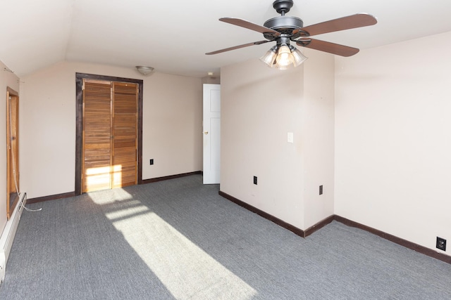 interior space with vaulted ceiling, carpet flooring, a ceiling fan, and baseboards