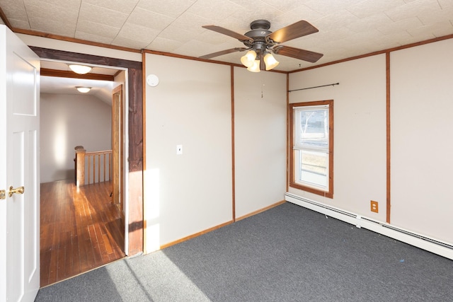 empty room featuring carpet floors, ornamental molding, baseboard heating, and a ceiling fan