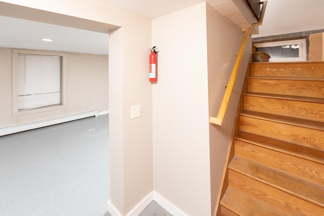 stairway with baseboard heating, baseboards, and recessed lighting