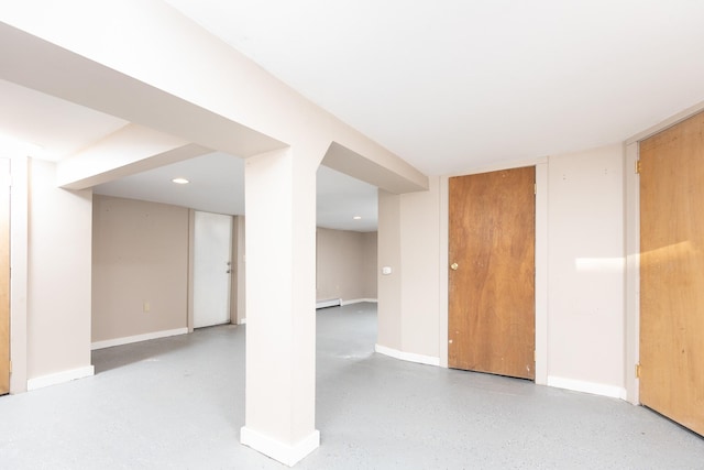 finished basement with a baseboard radiator and baseboards