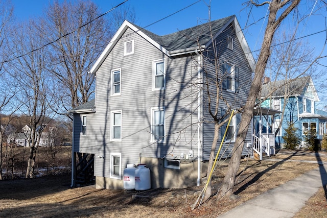 view of property exterior with roof with shingles