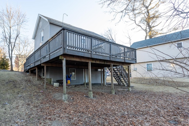 back of house featuring a shingled roof, stairs, a carport, and a wooden deck