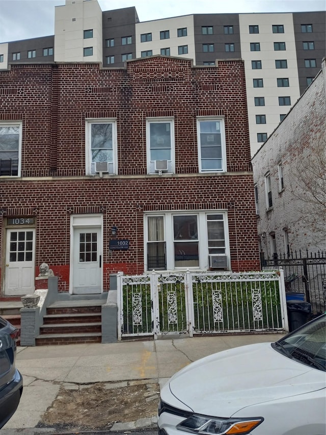 view of building exterior with a fenced front yard and cooling unit