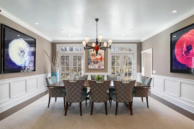 dining space with ornamental molding, french doors, and a decorative wall