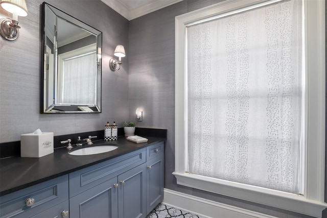 bathroom with ornamental molding, vanity, baseboards, and wallpapered walls