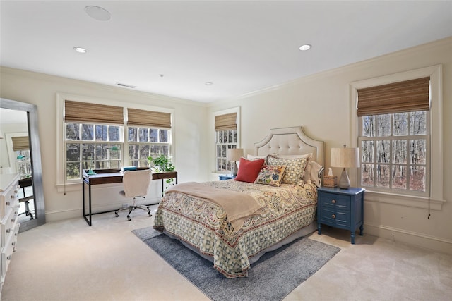 bedroom with ornamental molding, light colored carpet, visible vents, and baseboards