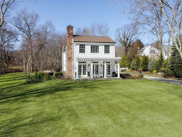 rear view of house with a lawn, a chimney, and a pergola