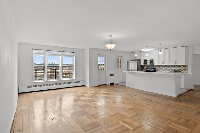 kitchen featuring a baseboard radiator, white cabinets, appliances with stainless steel finishes, pendant lighting, and tasteful backsplash