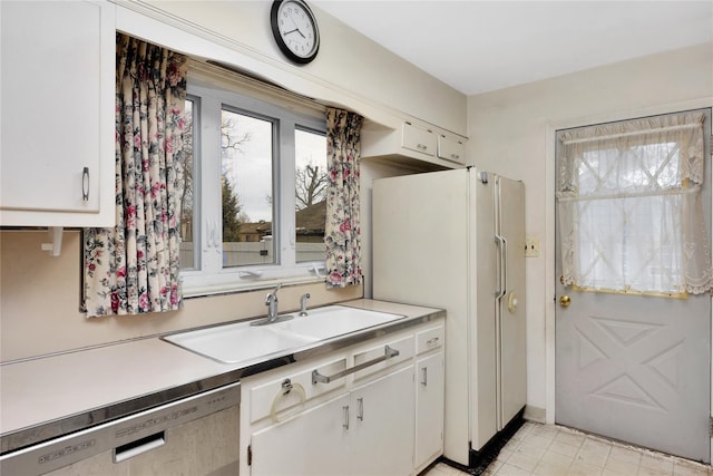 kitchen with a sink, white cabinetry, light countertops, and stainless steel dishwasher