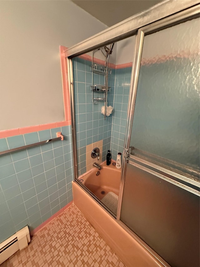 bathroom featuring tile walls, a baseboard radiator, wainscoting, combined bath / shower with glass door, and tile patterned floors