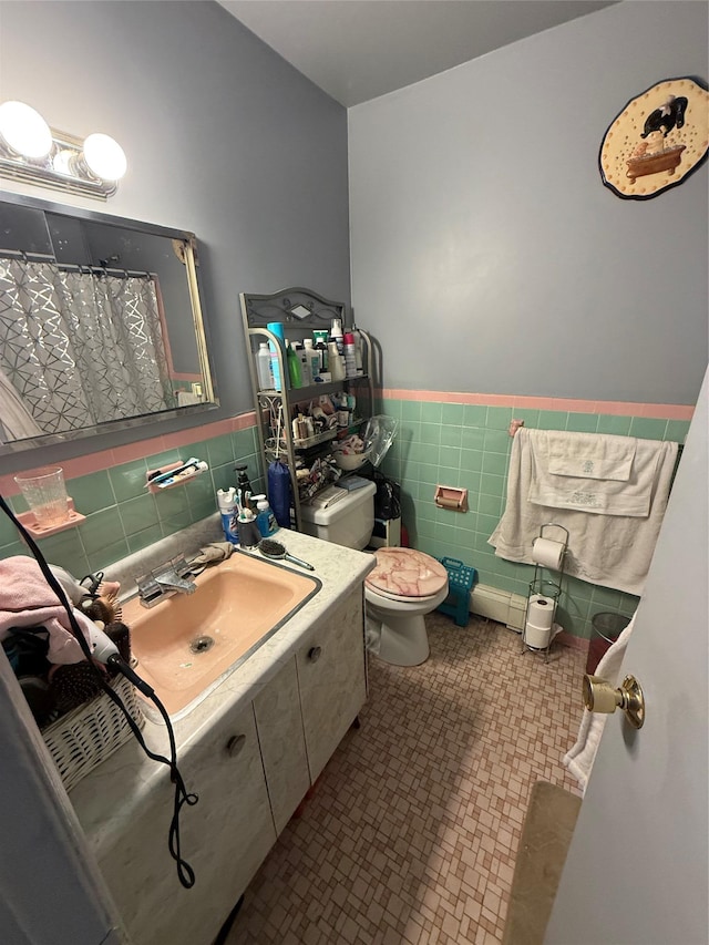 full bath with wainscoting, toilet, tile patterned floors, vanity, and tile walls