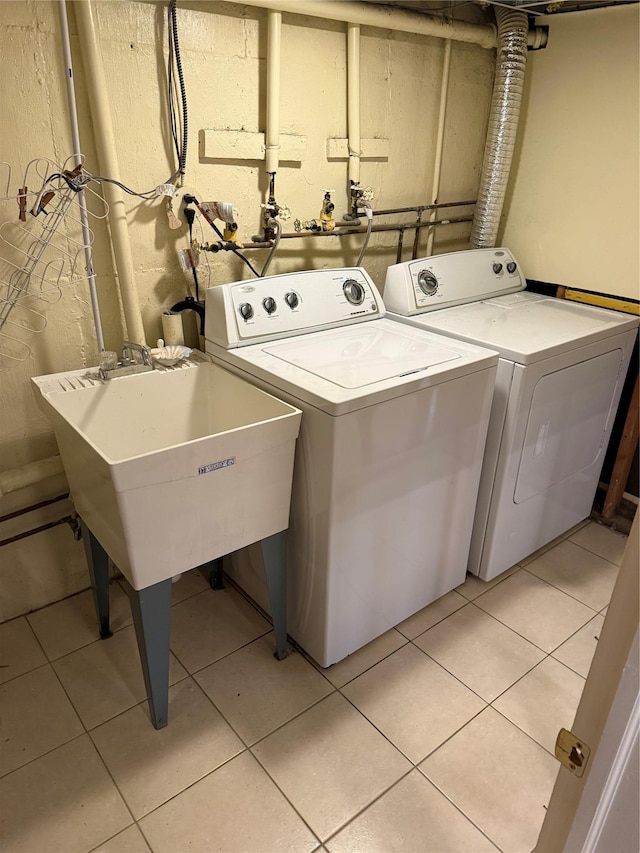 clothes washing area featuring light tile patterned floors and washer and dryer