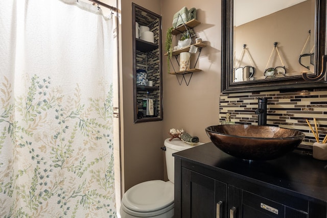 bathroom with toilet, a shower with curtain, tasteful backsplash, and vanity