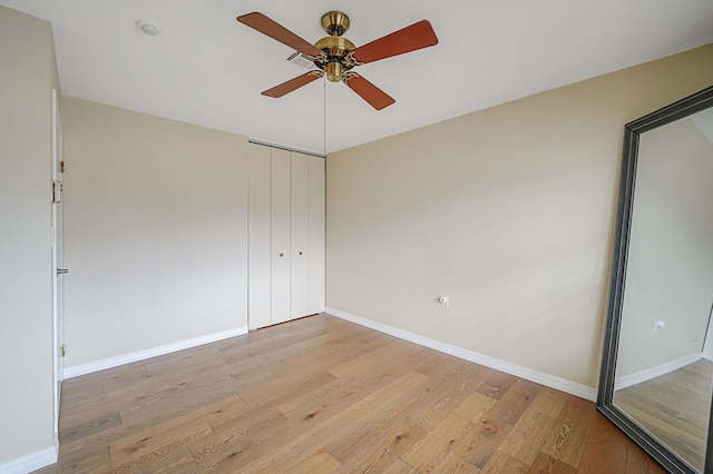 unfurnished bedroom featuring a closet, baseboards, ceiling fan, and light wood finished floors