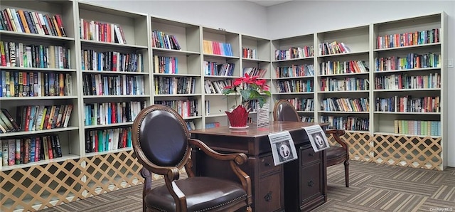 carpeted office space with wall of books