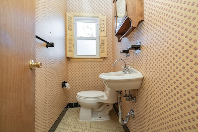 bathroom with a sink, tile patterned flooring, toilet, and wallpapered walls