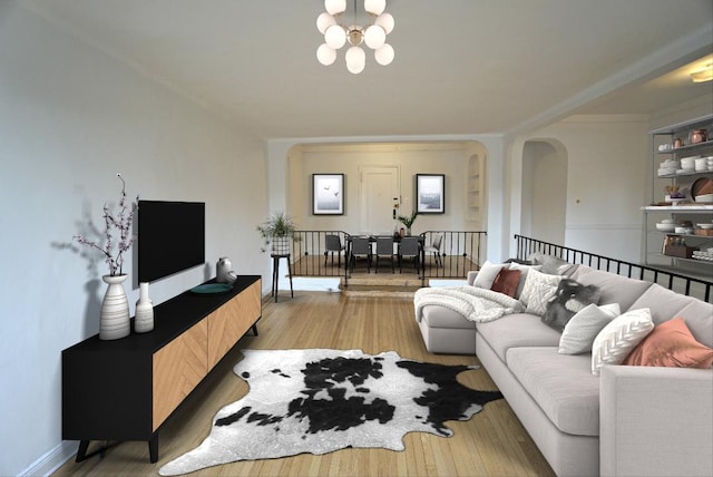 living area with a chandelier, arched walkways, baseboards, and wood finished floors