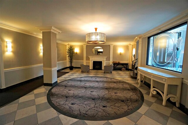 interior space with a fireplace, baseboards, tile patterned floors, decorative columns, and crown molding