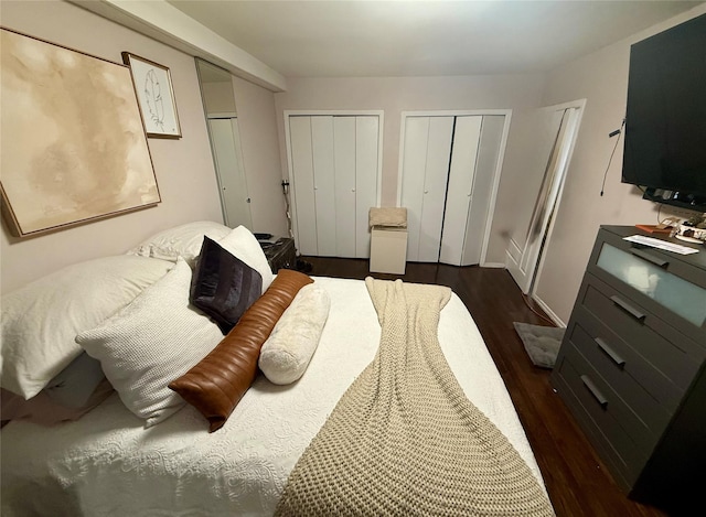 bedroom featuring dark wood-style flooring and two closets