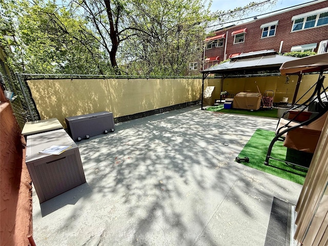 view of patio / terrace featuring a gazebo, a jacuzzi, and fence