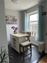 dining space featuring dark wood-type flooring, breakfast area, and baseboards