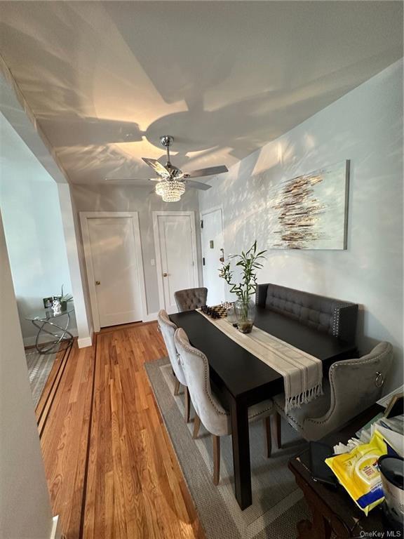 dining room featuring light wood-style floors, ceiling fan, and baseboards