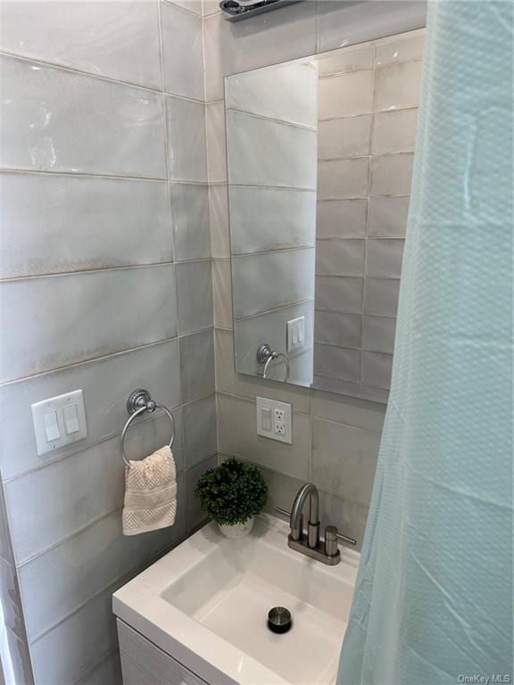 full bath with curtained shower and a sink