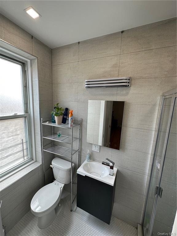 full bathroom featuring a stall shower, vanity, toilet, and tile patterned floors