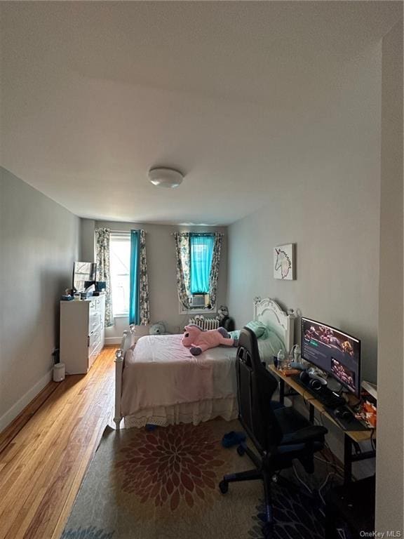 bedroom with baseboards and wood finished floors