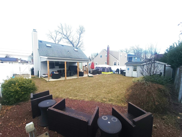 view of yard featuring an outbuilding, a patio area, and fence