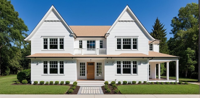 view of front of house with covered porch, a balcony, and a front lawn